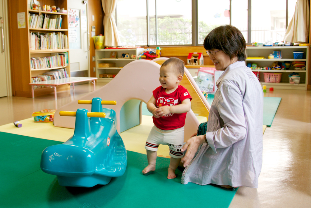 遊具で遊ぶ子供とその祖母の写真